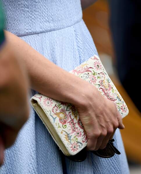 Kate Middleton assortit sa robe bleu  pastel d'une pochette colorée très printanière.