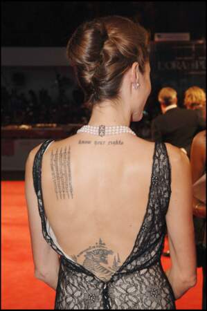 Angelina Jolie multiplie les tatouages avec un tigre en bas du dos et des slogans politiques sur la nuque.