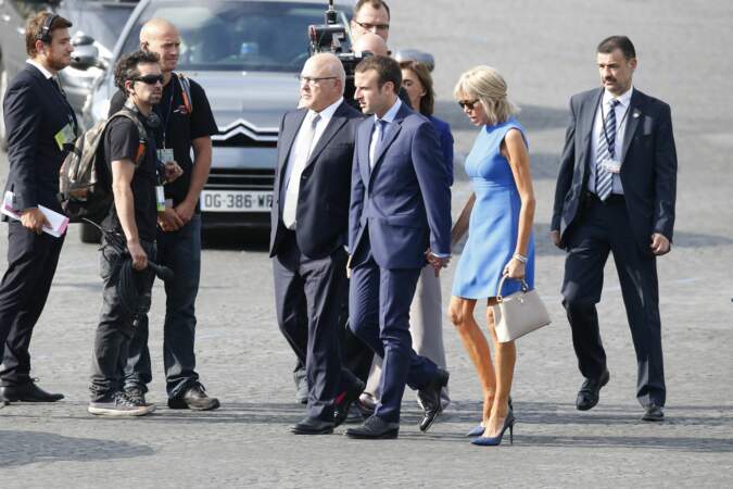 Brigitte et Emmanuel Macron en route vers la tribune présidentielle pour le défilé du 14 juillet 2015. C'est la première fois que le couple est photographié à cette occasion. Un an plus tôt, Emmanuel Macron, secrétaire général adjoint de l'Elysée, a été nommé ministre de l'Economie.