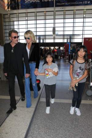 Johnny Hallyday, avec son épouse Laeticia et ses deux filles, Joy et Jade, à l'aéroport de Los Angeles, en juin 2016. 