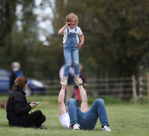 Mike Tindall s'amuse avec sa fille Mia dans l'herbe alors que sa femme Zara Tindall participe à la compétition Land Rover Burghley Horse Trials à Stamford, le 7 septembre 2019.