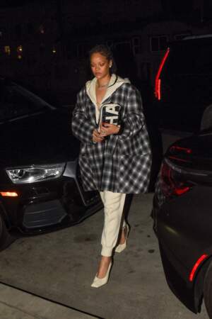 Pour un look urbain, la chanteuse Rihanna superpose une surchemise ample au dessus de son sweat beige oversize 