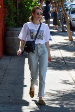 Emma Roberts stylée à Los Angeles, elle mixe son t-shirt blanc à logo avec un pantalon droit taille haute et une paire de mules léopard.