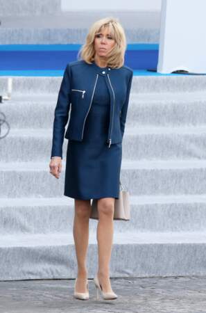 Brigitte Macron et son gimmick mode : le perfecto porté sur une robe droite, ici le 14 juillet 2017.
