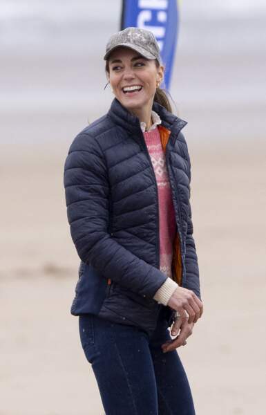 Kate Middleton en doudoune, jean, rangers et casquette sur la plage Saint Andrews,  le 26 mai 2021.