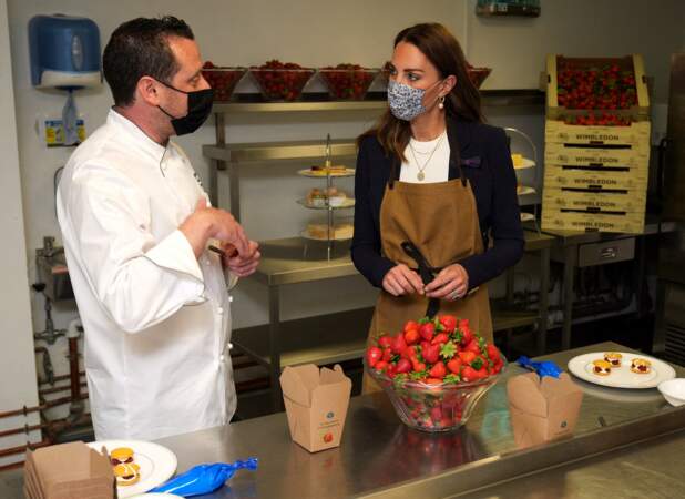 Kate Middleton aide à préparer des desserts aux fraises avec le chef Adam Fargin dans les cuisines du All England Lawn Tennis and Croquet Club de Wimbledon à Londres, le 2 juillet 2021.