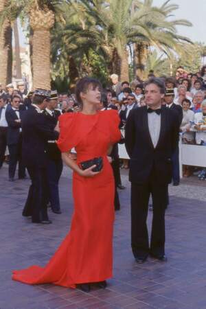 Sophie Marceau dans une robe rouge à maxi épaulettes, au côté de son compagnon et pygmalion Andrzej Zulawski, au Festival de Cannes en 1987.