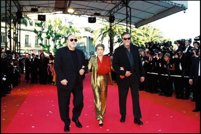 Catherine Deneuve en costume pailleté or et blouse en mousseline rouge Yves Saint Laurent, au Festival de Cannes, en 2000.