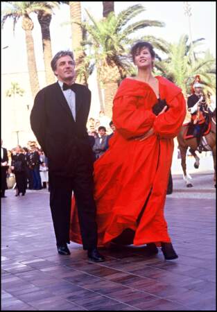 Sophie Marceau impériale dans un manteau en taffetas rouge, au côté de son compagnon et pygmalion Andrzej Zulawski, au Festival de Cannes, en 1987.