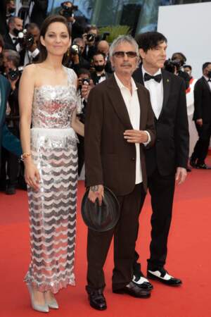 Aux côtés de Leos Carax et Russel Mael, Marion Cotillard a pris la pose, très chic dans une robe Chanel argentée, pour la montée des marches du film "Annette" lors de la cérémonie d'ouverture du 74ème Festival International du Film de Cannes, le 6 juillet 2021