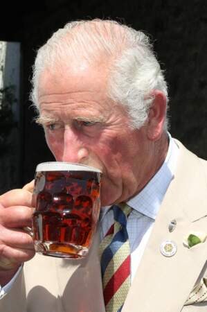 Peu importe si cela colle ou non au protocole royal, le prince Charles savoure sa pinte de bière dans un pub lors de sa visite à Iddesleigh, ce 21 juillet 2021.