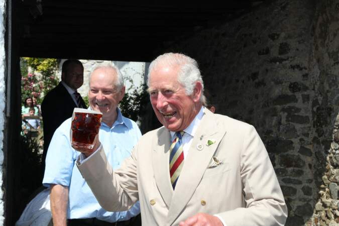 Le prince Charles, joyeux et décontracté, trinque avec les locaux lors de son passage dans un pub d'Iddesleigh, ce 21 juillet 2021.
