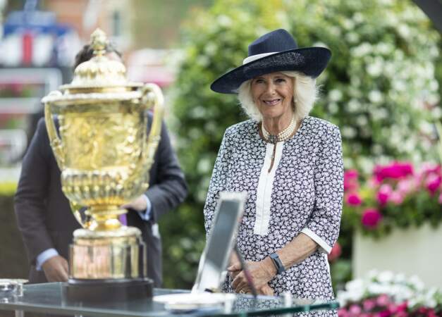 La duchesse de Cornouailles admire le trophée du King George Diamond Weekend dans son élégante robe fleurie.