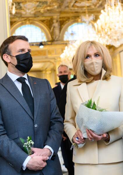 Brigitte Macron porte un masque nude coordonné à son tailleur le 1er mai 2021.