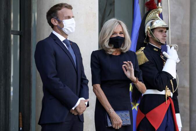 Brigitte Macron et l'art de l'accessoire : une pochette, sa montre fétiche, sa manchette et une bague.