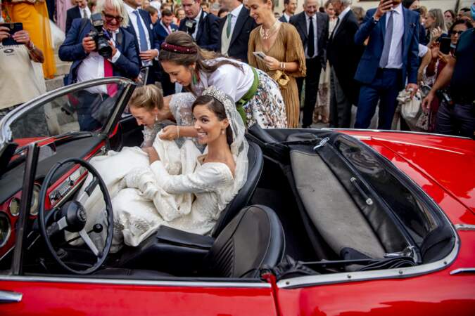 Le départ des mariés dans une sublime voiture rouge.
