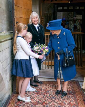 Une enfant de chœur a offert une bouquet de fleurs à la reine Elizabeth II après le service d'action de grâce donné en l'abbaye de Westminster pour marquer le centenaire de la Royal British Legion, à Londres, le 12 octobre 2021.