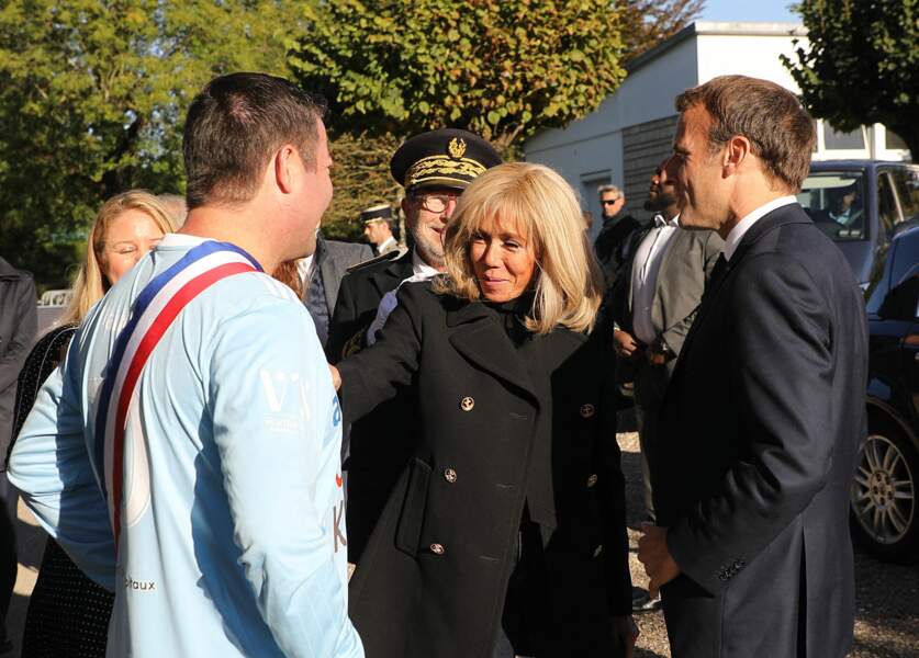 Karl Olive, le maire de Poissy accueille le président de la République Emmanuel Macron, accompagné de sa femme Brigitte Macron, qui arrive pour participer au match de football caritatif, au profit de la Fondation Hôpitaux de Paris-Hôpitaux de France dans la cadre de l'opération "Pièces jaunes", le 14 octobre 2021. 