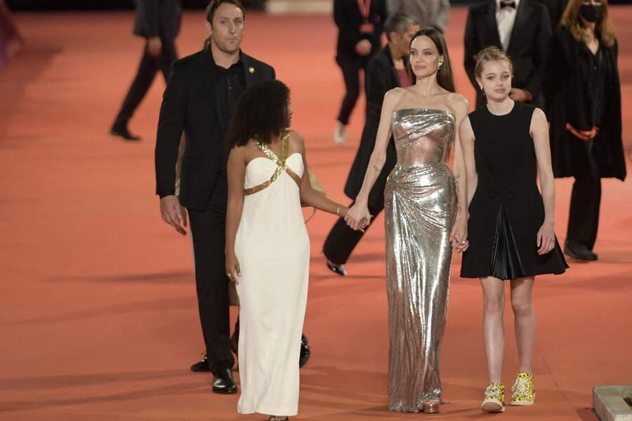 Si Angelina Jolie et Zahara sont dans un style très glamour, Shiloh se la joue plus moderne en mixant robe noire et baskets jaunes Sawa Shoes à 