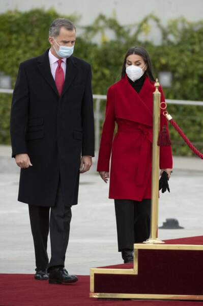 Letizia d'Espagne égaye son total-look noir (le pull, le pantalon, les gants, les bottines) grâce à son manteau rouge.