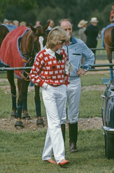En juin 1983, la princesse Diana apparaît au Guards Polo Club de Windsor, vêtue de l'une des pièces iconiques de son dressing. Le pull rouge orné de moutons blancs et du fameux mouton noir au niveau de la poitrine, signé Muir and Osborne pour leur marque Warm & Wonderful. 