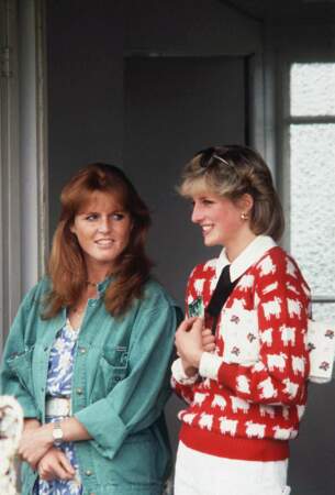 Lady Diana aux côtés de Sarah Ferguson en 1983 lors d'un match de polo à Windsor. Son pull rouge mouton noir est si culte qu'il fut réédité en 2020 par la marque Rowing Blazers. La pièce a également inspiré le prince de la Pop britannique, Harry Styles en personne, qui fut aperçu à New York vêtu d'un pull sans manches au design similaire, en novembre 2019.