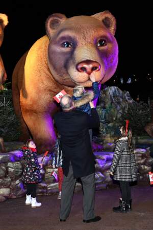 Le prince Albert porte son fils pour qu'il touche le nez d'un ours en plastique au marché de Noël, le 3 décembre