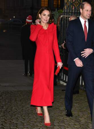 Kate Middleton porte un manteau long et coloré signé Catherine Waler, ainsi qu'une pochette et des escarpins assortis.