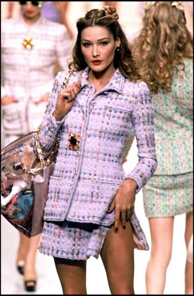 Carla Bruni porte l'icônique ensemble en tweed violet lilas lors du défilé de mode Chanel collection prêt-à-porter printemps-été 1995, à Paris, le 10 octobre 1994.