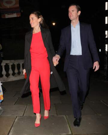 Pippa Middleton coordonne un top rouge à un pantalon rouge mais aussi une minaudière et des escarpins rouges.