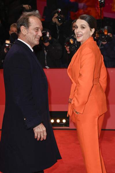 Regard par dessus l'épaule, Vincent Lindon et Juliette Binoche prennent la pose sur le red carpet du film "Avec amour et acharnement" lors de la 72ème édition du festival international du film de Berlin le 12 février 2022.
