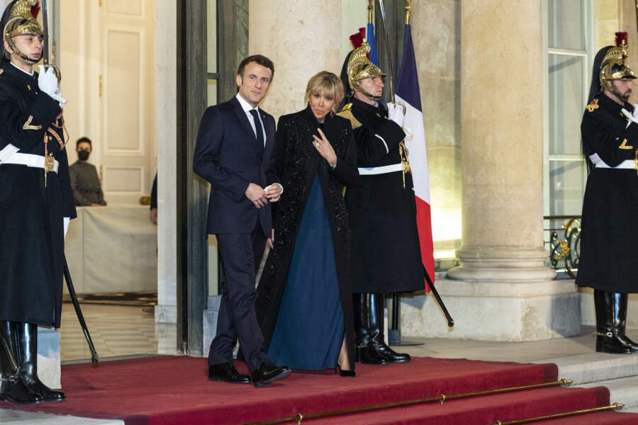 Le président Emmanuel Macron et Brigitte Macron en robe bleue nuit et long manteau noir
