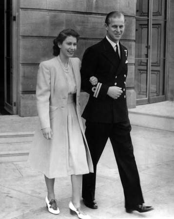 La princesse Elizabeth au bras du lieutenant Philip Mountbatten, le jour de l'annonce des fiançailles du couple, depuis Buckingham Palace, le 10 juillet 1947.