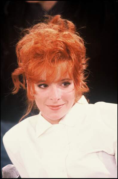 Mylène Farmer en 1987 : cheveux roux flamboyant et chignon flou très volumineux