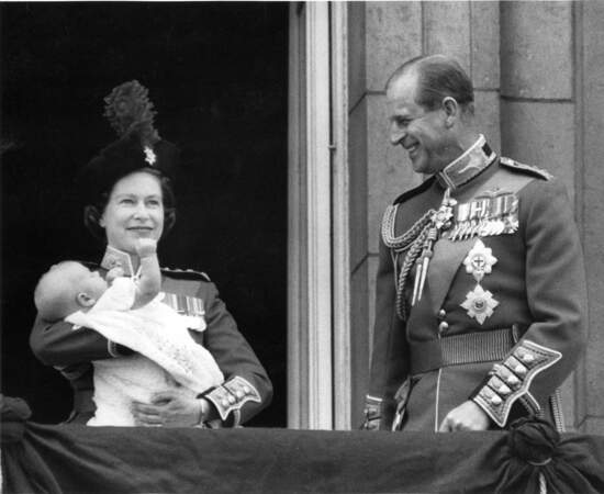 Elizabeth II tient dans ses bras le prince Edward, sous le regard ému du prince Philip, sur le balcon de Buckingham Palace, le 13 juin 1964.
