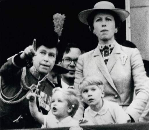 La reine Elizabeth II aux côtés de sa fille, la princesse Anne, et de son petit-fils, Peter Phillips (à gauche), au balcon du palais de Buckingham, à Londres, le 6 juin 1980.