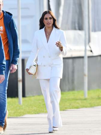 Meghan Markle sublime dans ce total look blanc et doré signé Valentino pour le costume et le sac à mains et Aquazzura pour les escarpins.