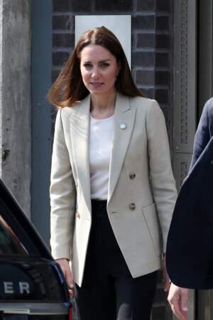Kate Middleton accroche à sa veste de costume un badge aux couleurs du drapeau ukrainien,  le 21 avril 2022.