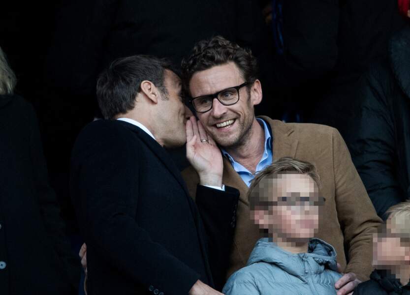 Emmanuel Macron chuchotant à l'oreille de son petit frère, en avril 2019, au Stade de France. 