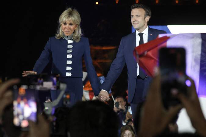 Brigitte Macron craque pour un ensemble de costume bleu marine. La veste est sublimée par une multitude d'attaches argentées, le 24 avril 2022.