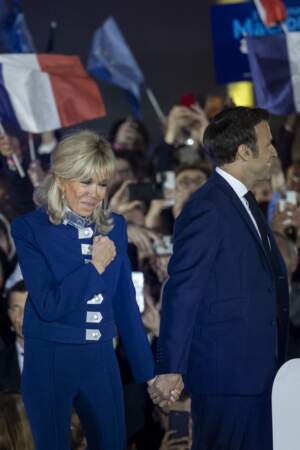 Brigitte Macron choisit une longue barrette plate et nacrée qu'elle dépose sur ses cheveux. 