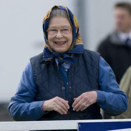 Pour compléter son total look bleu, la reine Elizabeth II a noué un foulard bleu marine, lors du Royal Horse Show, le 15 mai 2009.