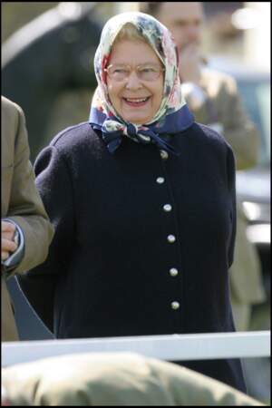Lors de la première journée du Royal Windsor Horse Show, le 12 mai 2005, la reine Elizabeth II a assorti son foulard fleuri avec son manteau en laine bleu marine.