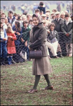 La reine Elizabeth II a jeté son dévolu sur un foulard rouge bordeaux et kaki lors d'un événement à Badminton, le 15 avril 1983.