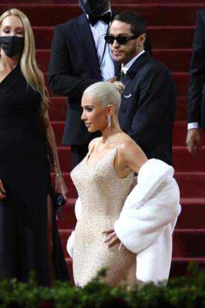 Kim Kardashian mise pour une mise en beauté plaquée et tirée sur sa nouvelle couleur blonde platine. Elle attache ses cheveux en un chignon haut. 