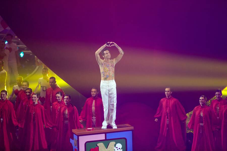 Mika stylée dans un pantalon évasé avec un haut transparent à motifs brodés à l'Eurovision