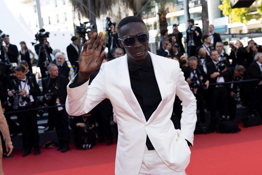 Khaby Lame très chic dans un costume blanc pour la montée des marches du film « Armageddon Time » lors du 75ème Festival International du Film de Cannes, le 19 mai 2022.