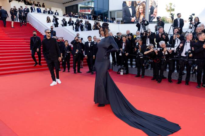 Aya Nakamura femme fatale sur le tapis rouge du 75ème Festival International du Film de Cannes dans une longue robe moulante noire à la longue traine, le 19 mai 2022.