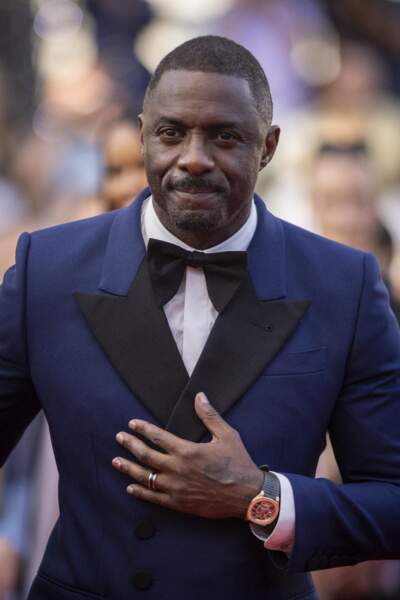 Idris Elba vêtu d'un costume bleu marine cintré avec un noeud papillon noir et des chaussures habillées à Cannes