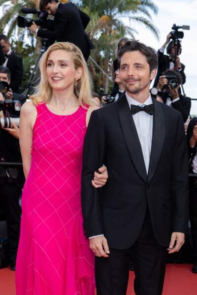 Au bras de Raphaël Personnaz, Julie Gayet a fait sensation dans une robe à volants rose fuchsia pour la montée des marches du film "L'Innocent", lors du 75ème Festival International du Film de Cannes, le 24 mai 2022. 